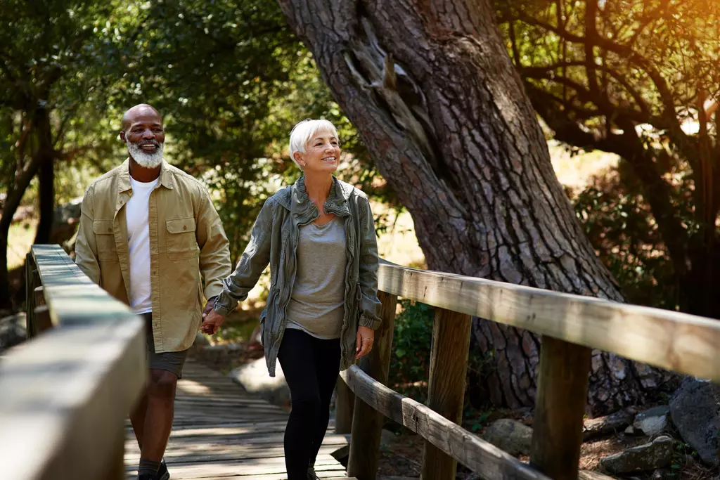 Two people walking over a bridge 