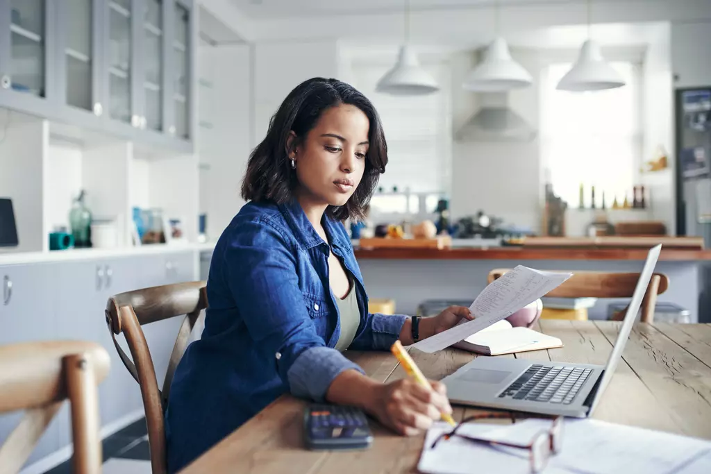 Women sitting at table looking at laptop.