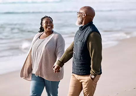 Older couple walking on the beach