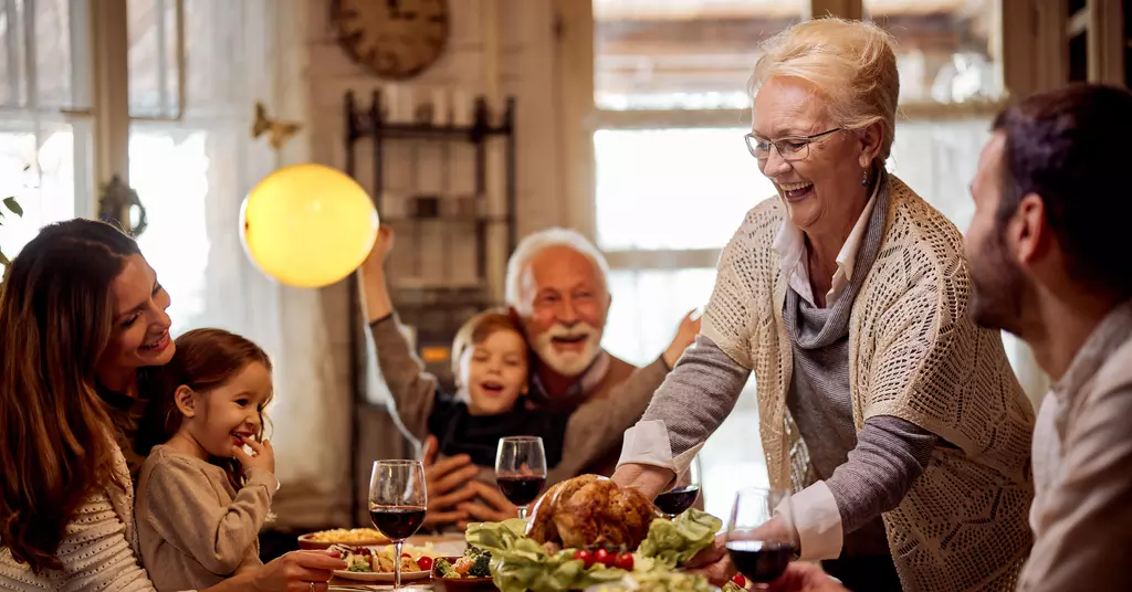 A family enjoying a Thanksgiving meal around a table. 