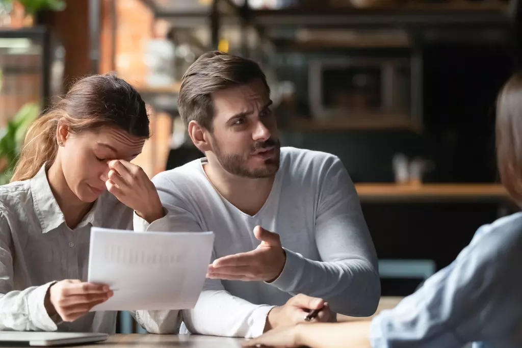 two stressed people looking at paperwork 